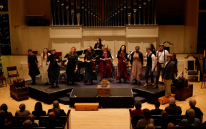 An ensemble performs on a raised platform at Bath Church