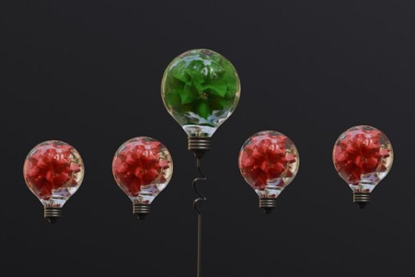 A line of light bulbs have red and green ribbons inside.